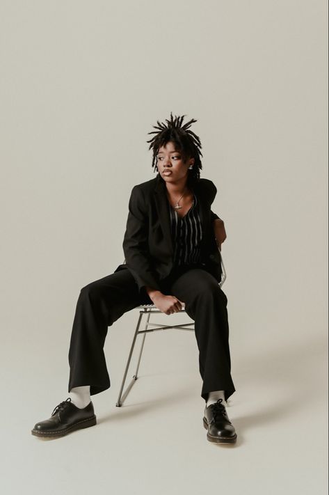 Black woman on locs wearing a suit, sitting on a chair in a studio photoshoot picture. Sitting Fashion Poses, Studio Stool Photoshoot, Grad Photo Outfit Ideas, Wooden Stool Photoshoot, Street Style Studio Photoshoot, Chair Modeling Poses, Photoshoot With Locs, Hotel Hallway Photoshoot, Women In Suits Photoshoot