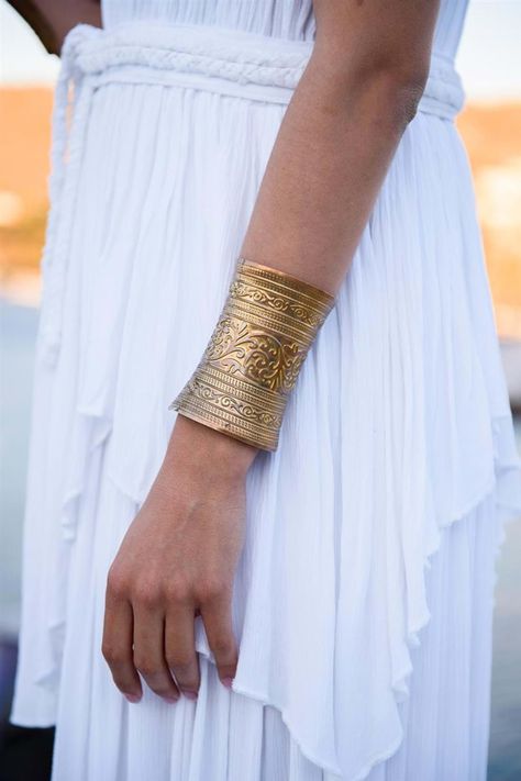 Gold cuff bracelet and a grecian gown for the Greek Goddess performer at the luxury anniversary reception in Mykonos | Mykonos Wedding Planner & Designer: @mitheoevents Photo: @mindartphotography Venue: @kivotoshotel | #mitheoevents #weddingplannergreece #mykonosweddingplanner #destinationweddinggreece #mykonoswedding #mykonosanniversary #weddingreception #weddingparty #grecianwedding #ancientgreece #weddingdecor #weddingstyling #grecianstyle #grecianoutfit #grecianweddingdress Grecian Outfit, Ancient Pillars, Ancient Greece Architecture, Greece Theme, Greek Wedding Theme, Ancient Greek Bracelet, Diana Artemis, Island Scenery, Greek Accessories