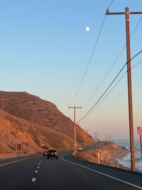 pacific coast highway on a curve around an amber mountain at sunset with moon visible in the still-blue sky just beyond the telephone wires, ocean tide coming in toward the rocky beach off to the right California Cool Aesthetic, Pacific Highway California, Highway One California, Norcal Beach Aesthetic, Rural California Aesthetic, Sonoma California Aesthetic, Y2k California Aesthetic, Great Ocean Road Aesthetic, Southern California Aesthetic Home