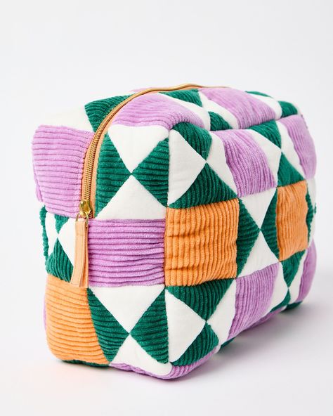 Fabric wash bag made from patchwork orange, green and purple corduroy sewn in a geometric pattern.