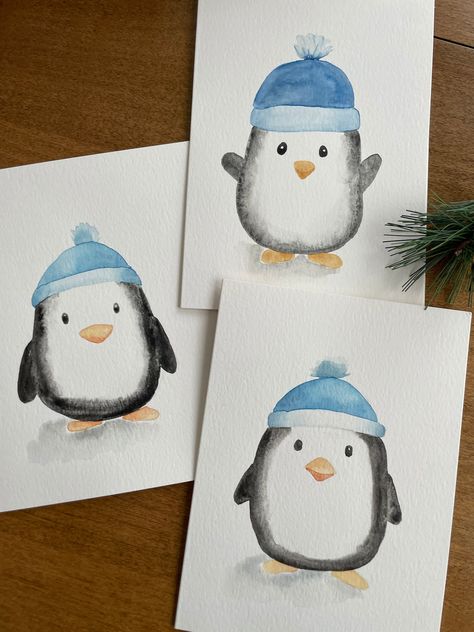 Description: Bring a touch of charm to your holiday greetings with this adorable winter penguin watercolor card! This 5x7 card features a hand-painted watercolor illustration of a cute penguin wearing a cozy blue hat, making it perfect for spreading warmth and joy during the holidays. Key Features: ❄️Original Watercolor Art: Each card showcases a unique, hand-painted winter penguin, ensuring that no two cards are exactly alike. ❄️Perfect for the Holidays: Ideal for Christmas, winter celebrations, or any festive occasion. ❄️Blank Inside: Plenty of space for your personalized message, making it suitable for various occasions. ❄️Quality Materials: Made with premium Strathmore watercolor paper for a beautiful and lasting finish. ❄️ White Envelope Included: Comes with a high-quality white envel Easy Holiday Watercolor Cards, Winter Cards Diy, Christmas Cards Hand Made, Simple Painted Christmas Cards, Simple Christmas Cards Watercolour, Christmas Painted Cards, Watercolour Xmas Card Designs, Mini Christmas Watercolor Paintings, Winter Cards For Kids