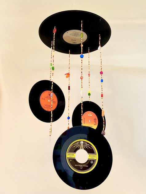 DIY hanging vinyl mobile retro room decor 70’s Vinyl Hanging Decor, 70s Room Decor Diy, Crafts From The 1970's, Crafts From The 70s, Vinyl Record Wind Chime, Record Hanging Ideas, Vinyl Record Projects Upcycle, Hanging Records From Ceiling, Retro Room Decor Diy