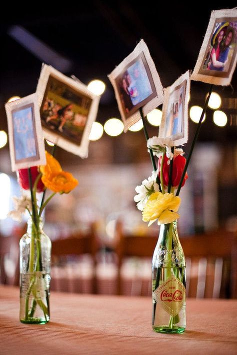 Photos On Sticks Centerpieces, Favors Rehearsal Dinner, Photos Centerpiece Ideas, Photos For Centerpieces, Using Photos As Centerpieces, Photo Vase Centerpiece, Diy Wedding Anniversary Decorations, Coke Bottle Centerpiece, Simple Event Table Decor