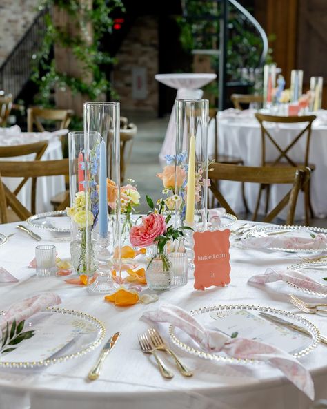 you kidding me 🥲 these pastel tapers added so much to this tablescape!! A sweet bud quartet paired with a trio of taper candles is one of our favorite ways to add a little something something to a guest table. here, we opted for mini centerpieces on some of our farm tables + invested in smilax vines to give life to the venue overall - which is something ALL your guests can enjoy, no matter which table they’re sat at. It’s all about creating an atmosphere! Planning @perfectlyplannedtx Venue... Table Wedding Favors, Simple Pastel Centerpieces, Outside Wedding Table Set Up, Pastel Wedding Round Table, Bud Vase Table Centerpiece, Simple Garden Wedding Decorations, Pastel Round Table Decor, Colorful Wedding Table Decorations, Bud Vases And Taper Candles Centerpiece