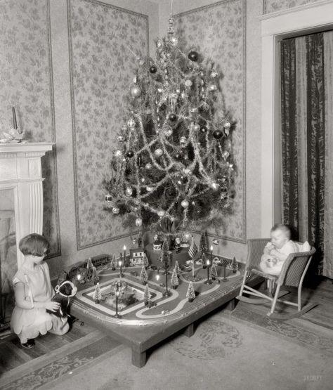 Photo of a decorated Christmas tree in 1928. It has a train and bottlebrush trees ,set up underneath the tree. Christmas Pictures Vintage, Old Time Christmas, Vintage Christmas Photos, Ghost Of Christmas Past, Christmas Pics, Christmas Train, Old Christmas, Old Fashioned Christmas, Antique Christmas