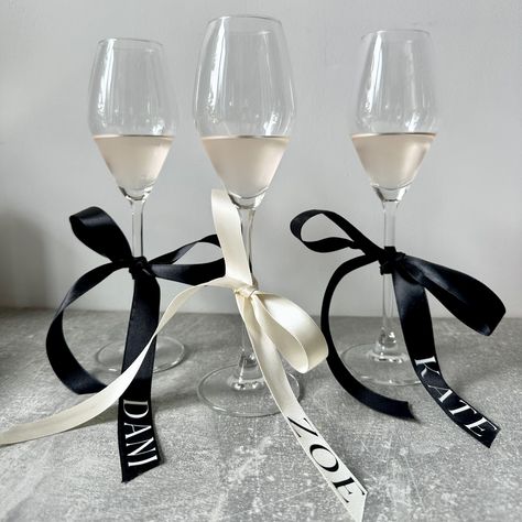 Another set of bows all sent out… These bows are already proving popular! Who else is loving the bow trend? I know I definitely am ( hint to my own wedding there 🙊 ) other colours optional of course just get in touch. Always on hand to help. X Bow Place Setting Wedding, Ribbon On Wine Glasses, Bridesmaid Proposal Dinner Ideas, Black Bow Wedding Decor, Bows On Champagne Glasses, Personalised Party Favours, Bow Name Cards, Black Tie Bridal Party, Dinner Party Name Cards