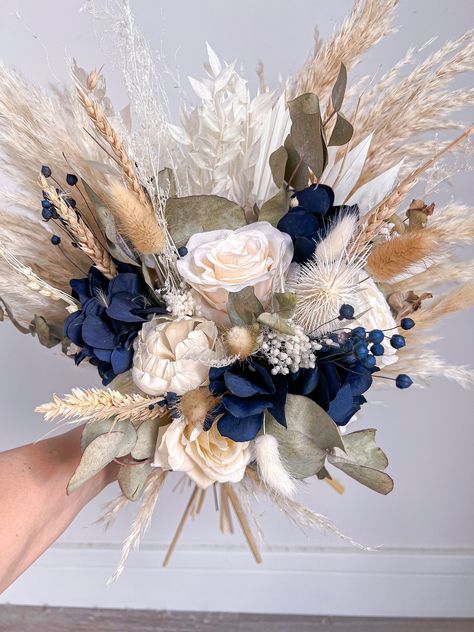 Stunning navy blue, neutral and sage green everlasting bouquet, made up of artificial roses, preserved and dried flowers including pampas grass. These bouquets are amazing if you would like a keepsake from your wedding day, they will last years and they need little to no maintenance!  Each bouquet is bespoke, made in my workshop in Oxfordshire, no two are the same. Please get in touch if you're wanting to tweak anything such as the colour and I will be more than happy to help. I can make buttonh Blue Bride Bouquet, Wedding Flowers Pampas, Navy Blue Wedding Bouquets, Navy Blue Bouquet, Blue Fall Wedding, Rose Bouquet Wedding, Wedding Bouquet Artificial, Navy Blue Wedding Theme, Dried Flower Bouquet Wedding