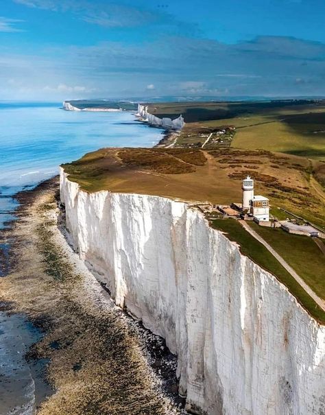 The White Cliffs of Dover is the region of English coastline facing the Strait of Dover and France. The cliff face, which reaches a height of 350 feet, owes its striking appearance to its composition of chalk accented by streaks of black flint, deposited during the Late Cretaceous. The cliffs, on both sides of the town of Dover in Kent, stretch for eight miles. A section of coastline encompassing the cliffs was purchased by the National Trust in 2016. Cliffs Of Dover, White Cliffs Of Dover, Nature Destinations, White Cliffs, East Sussex, Stunning View, Old Pictures, Wyoming, Great Britain