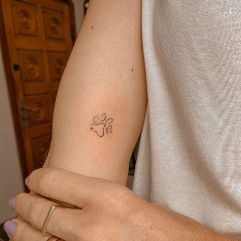 Outline Paw Tattoo, Cute Dog Tattoos Simple, Dog Arm Tattoos For Women, Simple Paw Print Tattoo Outline, Delicate Dog Paw Tattoo, Dog Paw Minimalist Tattoo, Dainty Dog Paw Tattoo, Simple Dog Print Tattoo, Paw Print Wrist Tattoos For Women