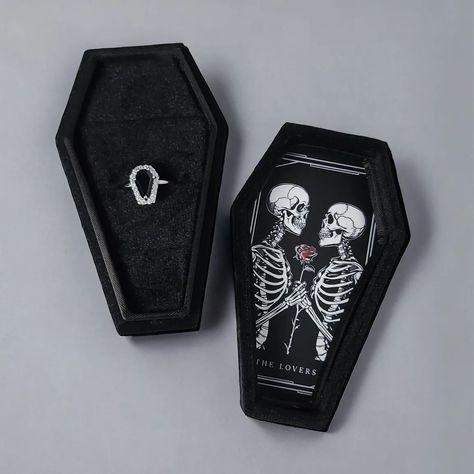 Custom coffin ring boxes now available 🖤 Whether to showcase your precious ring or to orchestrate a proposal of legendary proportions. Featured in black velvet, the interior offers three individual ring slots. All artwork done in our Melbourne studio. Different designs to select from. Add to your ring purchase or if we are currently making a ring for you let us know and we can add. Featured: The Lovers https://www.sapphirestudiosdesign.com/custom-coffin-ring-box Coffin Ring Box Wedding, Coffin Ring Box, Ring Boxes Engagement, Gothic Proposal, Ring Box Design, Making A Ring, Vampire Wedding, Black Lover, Coffin Ring