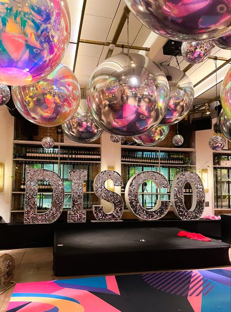 Amazing disco party theme party with disco shimmer letters and giant mirror balls . Decor by Dna. Letters by Big love letters . Disco Theme Parties Decorations, Hoco Themes, Soul Train Party, 70s Party Theme, Disco Theme Party, 70s Theme Party, Homecoming Themes, Giant Mirror, 70s Disco Party