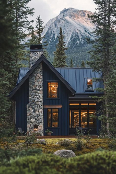 Modern cottage style mountain house facade with midnight blue corrugated metal cladding matte black window and door trim dark stone chimney forest. Check out all of these inspiring modern dark mountain houses that blend sleek design with nature’s rugged beauty for an exquisite home. Window And Door Trim, Dark Blue House Exterior, Design With Nature, Dark Blue Houses, Modern Cottage Homes, Modern Cottage Style, Rustic Lake Houses, Nordic House, Stone Chimney