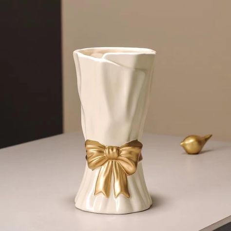 PRICES MAY VARY. 【High Quality Material】: This bow vase is suitable for any style or occasion. Each hand-made decorative vase is made of high-quality hand-crafted porcelain with uniform texture, the surface is made up of a smooth layer of glaze, which is particularly textured. 【Unique Design】: With its specially designed bow shape, this white vase brings a distinctive aesthetic to your bouquets, ensuring your flower arrangements catch everyone's eye. The color combination is very elegant and wil Wavy Ceramic Vase, Bow Vase, Gold And White Decor, Aesthetic Flower Vase, Vase Aesthetic, White Flower Vase, Unique Flower Vases, Vase Flowers, Art Deco Bathroom