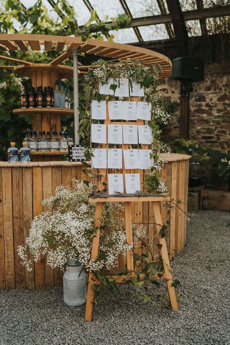 Foliage and gypsophila decorating the wooden seating chart and table plan sign next to the bar Seating Chart Wedding Clothespin, Clothes Pin Seating Chart, Unique Seating Chart Wedding Boho, Rustic Wedding Table Plan, Barn Wedding Seating Chart, Whimsical Wedding Seating Chart, Wooden Seating Chart Wedding, Woolshed Weddings, Table Chart Wedding