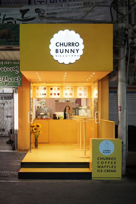 This bright yellow facade highlights a small takeaway café that sells mainly drinks and churros, located in Seoul, South Korea. Restaurant Exterior Design, Mini Cafe, Café Design, Small Coffee Shop, Food Kiosk, Restaurant Exterior, Cafe Shop Design, Coffee Shops Interior, Kiosk Design