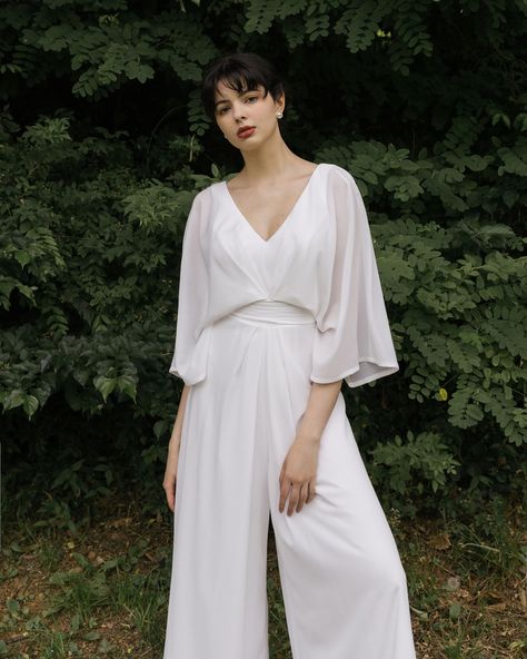 A perfect summer day, a white bridal jumpsuit, and a hint of berry 🤍 #BridalJumpsuit #WhiteJumpsuit #UniqueWeddingDress White Bridal Jumpsuit Plus Size, Plus Size Bridal Pantsuits, Nb Wedding Outfit, Wedding Outfit Nonbinary, White Outfits For Bridal Events, Elopement Jumpsuit, Masc Wedding Outfits, Gender Neutral Wedding Outfit, Wedding Overalls