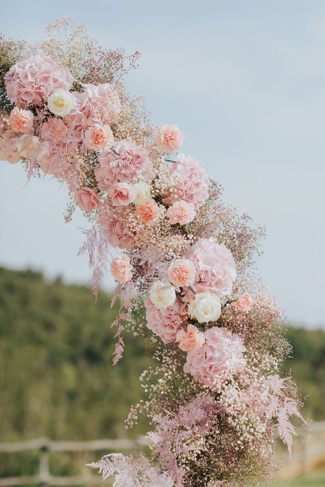 This dreamy blush pink floral arch features roses and baby's breath in ping, peach, and white Pink Flowers Aesthetic Wedding, Whimsical Wedding Arch Flowers, Delicate Pink Wedding, Pink Peach Flowers Wedding, Wedding Light Pink Bridesmaid Dresses, Blush Pink Spring Wedding, Pink And White Beach Wedding, Pastel Pink Wedding Decor, Pink Floral Wedding Arch