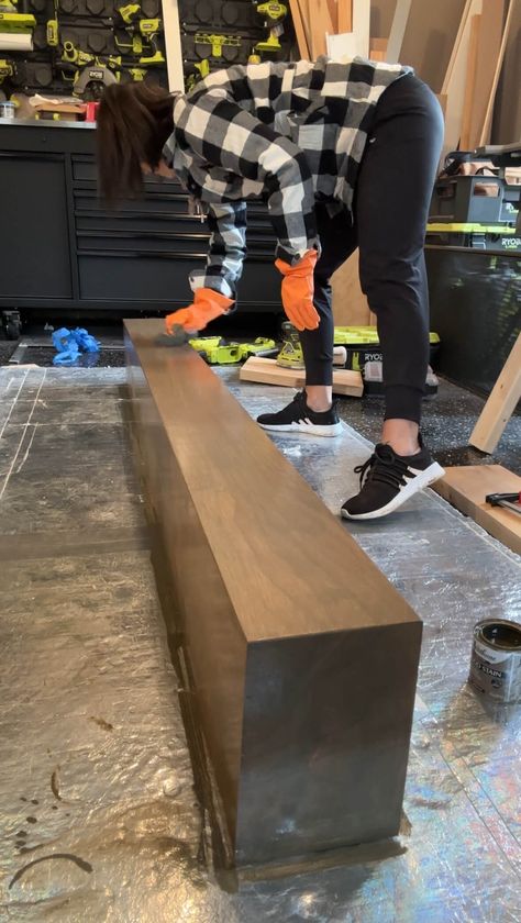 Melissa Tyler staining her DIY fireplace mantle. Staining Fireplace Mantle, Diy Floating Mantle Shelf, Fireplace Mantle Stain Color, Build Mantle Fireplace, Mantle Diy Wood How To Build, Black Fireplace Wood Mantle, Drywall Fireplace With Mantle, Concrete Fireplace With Wood Mantle, Diy Mantle Fireplace