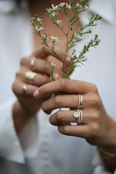 An engagement ring shot at a bridal photoshoot. a simple and dainty diamond bridal stacking ring set with wildflowers and a white blouse Dainty Diamond Engagement Ring, Ring Photoshoot, Jewellery Photography Inspiration, Ring Photography, Jewelry Product Shots, Creative Jewelry Photography, Jewelry Photography Styling, Jewelry Photoshoot, Ring Shots