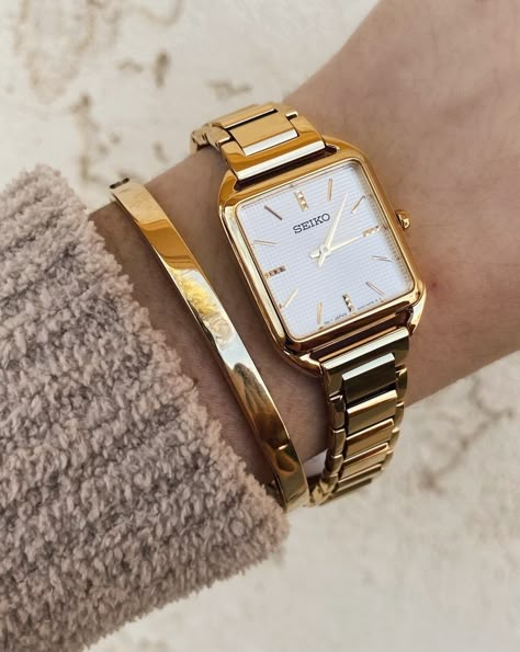 The perfect accessory to dress up any look. From the essentials collection, the Seiko SWR078 features a luxurious stainless-steel square case with an elegant gold finish. #HollandsJewelry #finejewelry #wheretraditionsbegin #traditionssince1918 #shoplocal #familyowned #Seikowatch #Seiko #SeikoStyle Square Face Gold Watch, Gold Square Watches Women, Seiko Essentials Watch, Seiko Watches Women Gold, Seiko Women Watch, Women Watches Classy Elegant, Square Watch Women, Watches For Women Classy, Seiko Gold Watch