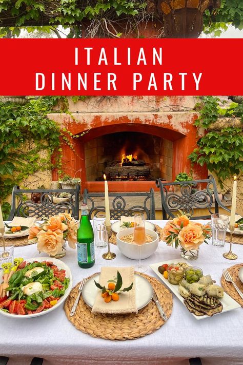 A beautiful dinner party set-up for 6 to 8 people. The table is set with a white linen table cloth in front of a rustic outdoor fireplace. On the table there is an antipasto platter and a large salad with burrata and tomatoes. The table setting includes peach-colored roses and gold candlestick holders with ivory taper candles. Italian Dinner Menu, Italian Food Party, Italian Dinner Party Decorations, Italian Food Menu, Vegetarian Dinner Party, Birthday Dinner Menu, Party Entrees, Dinner Party Ideas, Italian Dinner Party