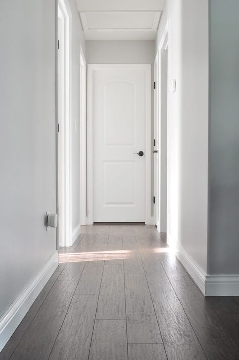 A fresh coat of paint can make all the difference. Check out this DIY home makeover from Ashley, of Little Glass Jar, to find tons of color inspiration. Ashley painted her hallway a neutral shade of Dolphin Fin to give it a tried-and-true classic style. Pair this light gray hue with bright white and dark accents to create an open and airy style. Behr Light Grey Paint Colors, Behr Gray Paint, True Grey Paint Color, Behr Paint Colors Grey, Looking Glass Paint, Dolphin Fin, Hallway Paint Colors, Paint Makeover, Light Grey Paint Colors