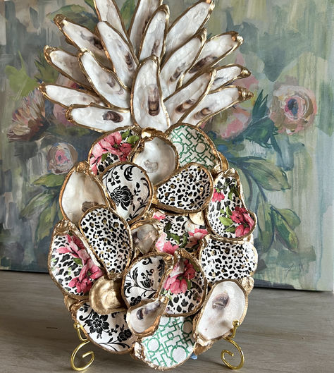 This Oyster Shell Pineapple Wall Art is handcrafted to bring a touch of coastal elegance to your living space. It features colorful decoupaged shells in patterns of leopard print and pink flowers surrounded by natural gilded shells arranged to form the unique shape of a pineapple. Each shell is hand-picked for its iridescent luster and unique shape to adorn the pineapple crown. Shell Wall Art Diy, Oyster Shell Wine Stopper Diy, Decoupage Oysters, Gilded Shells, Oyster Shell Pineapple, Decoupage Oyster Shells, Oyster Shells Diy, Pineapple Crown, Pineapple Wall Decor