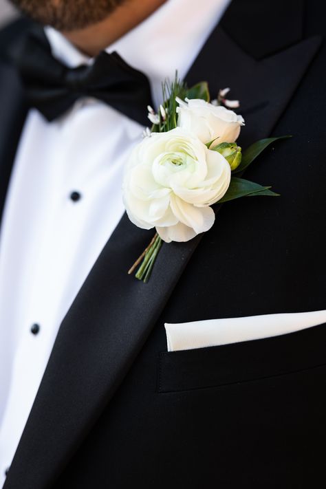 White ranunculus boutonniere with spray rose, genestra, and greenery accents. Stems partially wrapped in black velvet ribbon. PC: Ann Coen https://www.anncoen.com/photography Groomsman Flowers Groom Boutonniere, White Garden Rose Boutonniere, Boutinaire Ideas, Ranaculus Boutonniere Groomsmen, Classic Boutonniere Wedding, Modern Groom Boutonniere, Tulip Boutineer Groomsmen, Winter Wedding Boutonniere White, Neutral Wedding Boutonniere