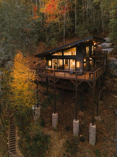 Surrounded by Wilderness, River Rock Treehouse With Open Loft has Wrap-Around Deck River Cabins On Stilts, Deck Overlooking River, River House On Stilts, Home Built Into Hillside, Cabin On A Hill, Minecraft Field, Property Vision Board, Tree House Architecture, House Near River