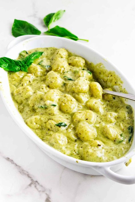 Creamy Pesto Gnocchi is a quick and easy single pan side dish. Fresh basil pesto, heavy cream, and Parmesan cheese come together to create a luxurious and satisfying sauce that perfectly complements the soft gnocchi. Gnocchi Pesto Cream Sauce, Basil Pesto Gnocchi Recipes, Creamy Pesto Gnocchi Recipes, Basil Gnocchi Recipes, Gnocchi Sauce Recipe, Pesto Gnocchi Recipes, Frozen Casserole Recipes, Creamy Pesto Gnocchi, Pesto Cream Sauce