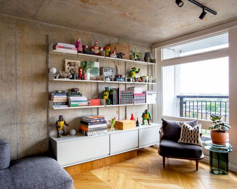 Off-white #vitsoe 606 shelves and cabinets wall-mounted on the bare concrete wall of a flat in the iconic Trellick Tower, northwest London—providing a stylish home for books, plants, astronauts and turtles...cowabunga! Plan your 606 system at vitsoe.com/606/inquiry Wall With Shelves, Floating Desks, Trellick Tower, System Furniture, Cozy Homes, Condo Living Room, Floating Cabinets, Ideas Hogar, Condo Living