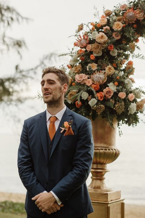 Boho Wedding Suit Grooms Blue, Terracota Suits For Men, Groomsmen Attire With Terracotta Bridesmaids, Navy Blue Suit With Rust Tie, Terracotta Wedding Suit Men, Navy Blue And Terracotta Groomsmen, Navy Blue Tux With Terracotta, Fall Mens Suits Wedding, Copper And Navy Bridesmaid Dresses