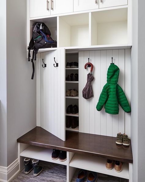 Our creative mudroom design features hidden shoe storage cabinets behind panelled doors dressed with coat hooks, perfect for a family. #allanchandondesign #mudroomdesign #familyfriendlydesign #customcabinetry #shoestorage #transitionaldesign #torontointeriordesign #torontodesigner #etobicoke #torontocustomhomes 📷@valeriewilcox Bench Cabinets, Painted White Cabinets, Mudroom Ideas Diy, Farmhouse Mudroom, Paint Cabinets White, Cabinets Painted, Grey Kitchen Designs, Mudroom Decor, Bank Design