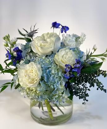 Floral Arrangements Blue And White, Small Bridal Shower Flower Arrangements, White Roses And Blue Hydrangeas Centerpiece, Hydrangea In Mason Jar Centerpieces, Floral Arrangements With Blue Hydrangeas, Blue Flower Centerpieces Diy, 25th Anniversary Flower Arrangement, Navy Blue Floral Centerpieces, Communion Flower Centerpieces