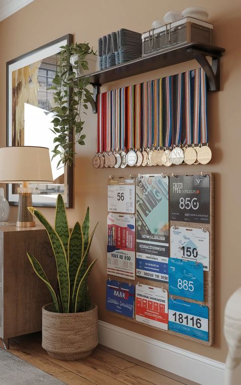 A creative display featuring marathon medals and race bibs organized on a wall-mounted rack. Ways To Display Medals, Diy Medal Display, Running Bib Display, Medal Display Ideas, Diy Medal, Display Medals, Race Bib Display, Bib Display, Race Medal Displays