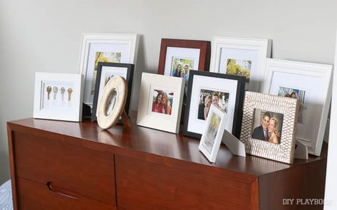 All your photo frames in one place can leave your surfaces feeling cluttered Picture Frame Arrangements, Displaying Family Pictures, Frame Arrangement, Picture Frame Table, Picture Arrangements, Picture Table, Photo Frame Display, Family Picture Frames, Photo Arrangement