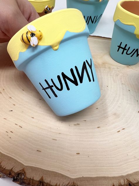 Handmade Colorful hunny pots 🍯 perfect for baby showers, birthdays or your nursery decor keepsakes. Item Description: 🍯 hand-painted & drizzled terra-cotta honey pots. Hand Painted and labeled " We have 2.6” & 3” that are perfect for cupcakes or mini gifts, 4.25" and 6” pots that make beautiful centerpieces or candy table jars. Diy Hunny Pot, Winnie The Pooh Table Centerpiece, Table Jars, Hunny Pot, Oxnard California, Mini Gifts, Baby Shower Sweets, Winnie The Pooh Cake, Bear Baby Shower Theme