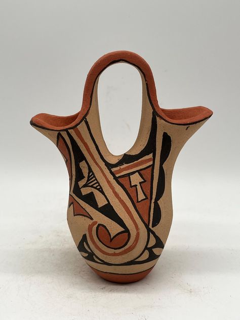 This exquisite Native American Jemez pottery wedding vase, crafted by artisan Martilla Madalena, reflects the rich cultural heritage of the Jemez Pueblo. Its hand-made design features intricate patterns, influenced by the Jemez Pueblo traditions. This collectible item is a testament to the craftsmanship and artistry of Native American pottery. It is a perfect addition to any collection and a special conversation starter. The vase authenticity is guaranteed as it has not been modified. This piece measures 5 3/4" tall and 4 1/2" wide. Pueblo Pottery Patterns, Native American Pottery Designs Pattern, Pottery Wedding, Wedding Vase, Acoma Pueblo Pottery, Pueblo Pottery, Native American Pottery, Wedding Vases, Conversation Starters