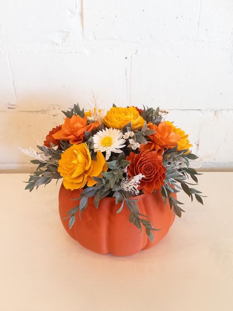 Welcome the warm and cozy feeling of fall with our pumpkin arrangement! Adorned with rich colors, this beautiful floral arrangement is the perfect addition to your autumn decor. Bring the beauty of the season into your home with this lovely piece. Our Pumpkin Spice Arrangement features sola wood and dried flowers in burnt orange, tangerine, orange and white in an exclusive orange pumpkin pot. Flowers last for years with proper care and never need watering.  Would make a great addition to your home decor or gift for any occasion!  Arrangement is approximately:  11"h x 11"w" for large including container (as shown) ♻️🌎 - Our original designed vases, boxes, and pots are 3d printed from a sustainable naturally sourced bioplastic. They come in a beautiful matte natural looking finish.  In addi Halloween Fresh Flower Arrangements, Pumpkin Decorating Flowers, Boo Brunch, Pumpkin Flower Arrangements, Pumpkin Pot, Pumpkin Floral Arrangements, Pot Flowers, 60th Birthday Decorations, Pumpkin Arrangements