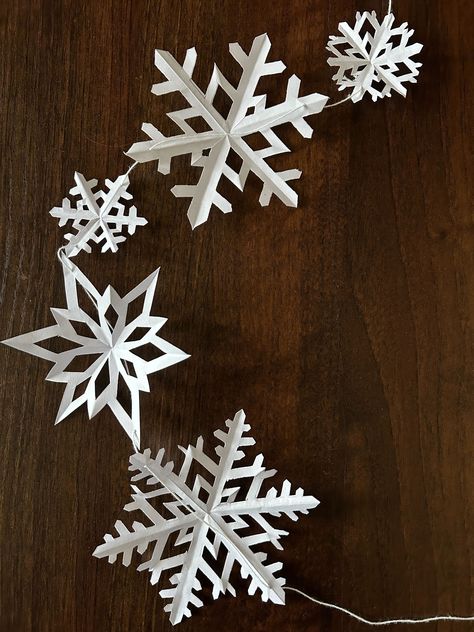 How to Make Paper Snowflake Garland for Christmas; Snowflake Designs Paper, Cool Paper Snowflake Patterns, Paper Snowflakes Chain, Make Your Own Snowflakes, Window Paper Decoration, How To Make Paper Snowflake Garland, Snowflake Paper Garland, Hanging Paper Snowflakes From Ceiling, Window Snowflakes Diy