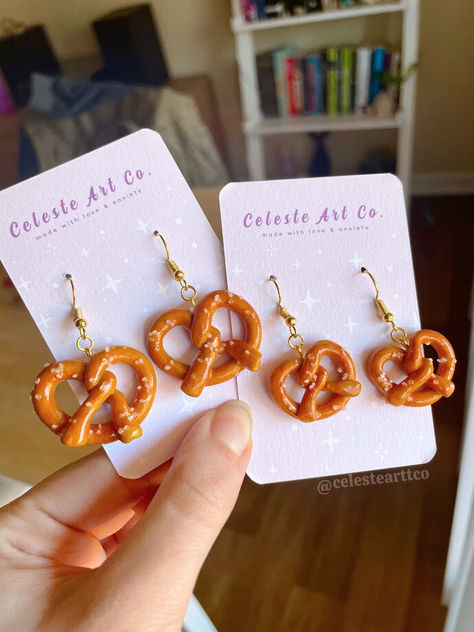 Introducing our Handmade Soft Pretzel Earrings, a delightful addition to your collection. Crafted from clay, each pair features lifelike pretzels with intricate detailing and a sprinkle of salt. Lightweight and comfortable, they're perfect for expressing your love for snacks all day long. These are the perfect earrings for Oktoberfest! #mini #minifood #food #foodie #earrings #jewelry #handmade #uniquegifts #giftsforher #uniqueearrings #funearrings #jewelry #handmadejewelry #pretzels #oktoberfest Salt Dough Earrings, Quirky Clay Earrings, Clay Earrings Aesthetic, Homemade Earrings Clay, Clay Pretzel, Air Dry Clay Earrings Diy, Fun Clay Earrings, Polymer Clay Food Earrings, Clay Food Earrings Tutorial