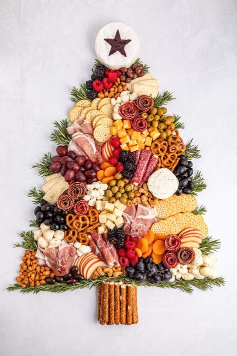 Charcuterie boards have taken the spotlight recently, and with the festive season approaching, why not create a charming Christmas tree charcuterie board for your holiday gathering? This playful and festive board can be crafted to any size you want. Picture an assortment of deliciously sliced meats and cheeses, paired with creamy cheeses, olives, crunchy pretzel sticks, and a colorful mix of fresh fruits and veggies. And you can feel free to add any other treats that tickle your festive fancy! Cheese Platter Ideas For Christmas, Grazing Board Ideas Christmas, Hanukkah Cheese Board, Christmas Tree Cheese Board Ideas, Christmas Fruit And Veggie Tray Ideas, Christmas Antipasto Platter Ideas, Christmas Grazing Table Decorations, Holiday Cookie Charcuterie Board, Christmas Charchuttere Board