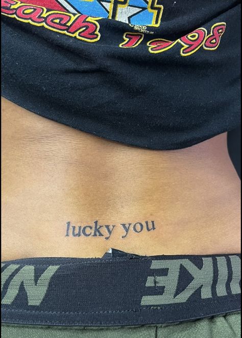 Lucky U Tattoo, Lucky You Tramp Stamp Tattoo, Tramp Tattoos For Women, Tramp Stamp Words Tattoos, Lucky You Tattoo Tramp Stamp, Stamp Tramp Tattoo Lower Backs, Back Stamp Tattoo, Lower Back Tattoo Black Women, Trap Stamp Tattoos Black Women