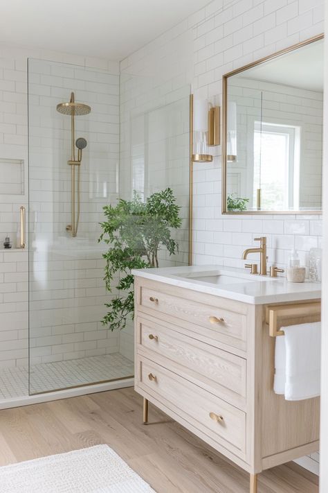 Explore this serene bathroom retreat with trendy brass fixtures and sleek subway tiles. Perfect for those seeking stylish yet functional modern bathroom ideas. #HomeDesign #BathroomDecor #ModernLiving White Bathroom Gold Hardware, White Subway Bathroom Tile Ideas, Bathroom Ideas Brass Fixtures, Gold Bathroom Fixtures, White Subway Tile Bathroom, Modern Bathroom Ideas, New House Bathroom, Full Bathroom Remodel, Serene Bathroom