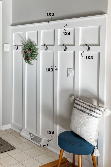 An entryway with a white board and batten wall, coat hooks, and a bench. Batten Board Walls Entryway With Hooks, Wainscoting Small Entryway, Short Foyer Entryway, Beadboard Wall Entryway, Board And Batten Narrow Hallway, Wainscoting Entryway Hooks, Board And Batten Coat Wall Entryway, Shiplap Or Board And Batten, Board And Batten Wall Sloped Ceiling