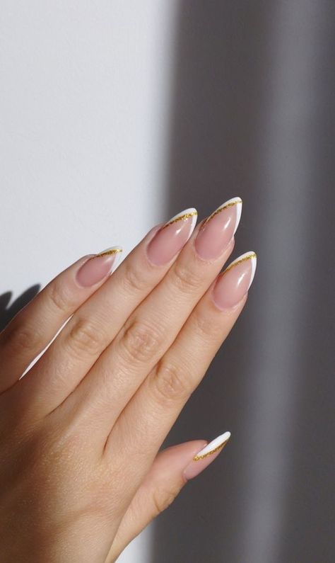 White And Gold Minimalist Nails, White French With Glitter Nails, Simple Gold Almond Nails, French Tip With Gold Line Nails, French Tip Acrylic Nails With Gold Line, Short Almond Nails Gold French Tip, White And Gold Acrylic Nails Almond, Simple Gold Accent Nails, Pointy White Tip Nails