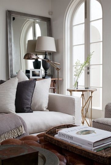 Amazing design by Coco Republic; white sofa, brown leather tufted ottoman, subtle but graphic chairs, and gold side tables to boot. Cream Living Room Decor, Cream Living Rooms, Coco Republic, Cozy Living Spaces, Mirror On The Wall, Tufted Ottoman, Furniture Office, Decoration Inspiration, Cool Ideas