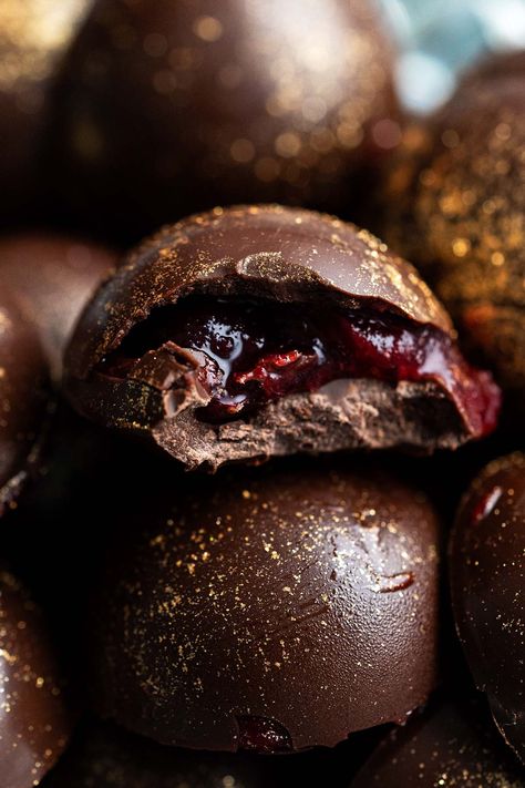 close up of cranberry chocolates with bite out of one to show cranberry cordial filling Cranberry Caramel, Unique Cranberry Recipes, Chocolate Cranberry Cookies, Chocolate Cranberry, Cranberry Truffles, Chocolate Cranberry Tart, Chocolate Covered Cranberries, Cranberry Chocolate, Dried Cranberry