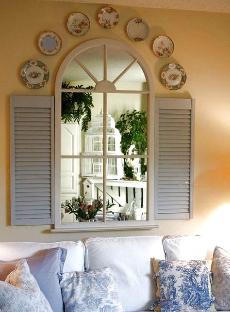 Arched Window Mirror with blue shutters & plates. Place a large mirror on a wall. Glue molding vertically and horizontally on mirror to make it look like a window & add shutters. Window With Shutters, Plates On The Wall, Old Window Shutters, French Country Decorating Bedroom, Fake Window, Faux Window, Old Shutters, French Country Bedrooms, Bedroom Decor Design