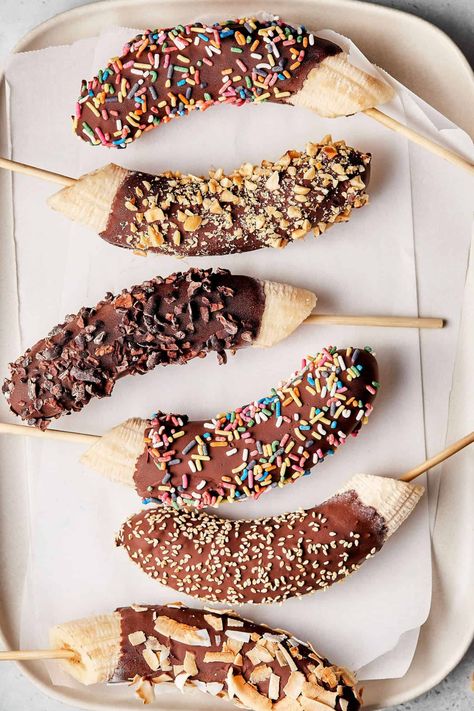 If you love the taste of chocolate and bananas, then you are going to love this recipe! My Frozen Chocolate Banana Pops are a a simple and easy way to enjoy a healthy, delicious sweet treat! As the weather begins to warm up, these are the perfect way to cool down and ease into the spring and summer months!A plate lined with parchment paper and six of the frozen chocolate banana pops Banana With Chocolate, Waffle Truck, Frozen Banana Treats, Frozen Banana Pops, Frozen Chocolate Bananas, Banana And Chocolate, Banana Frozen, Choco Banana, Chocolate Lollies